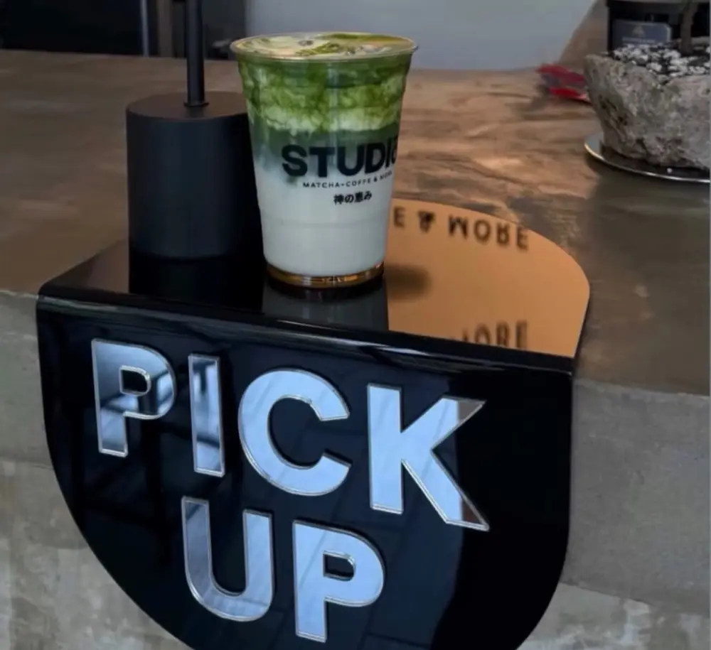 Un matcha de Studio sobre el letrero negro que dice PICK UP